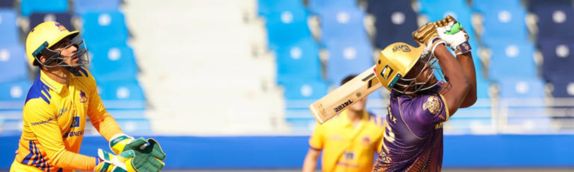 Cricketer batting in a stadium.