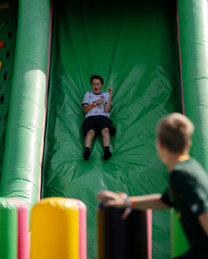 A child on the giant inflatable slide in the outdoor kids' zone at Emirates Dubai 7s