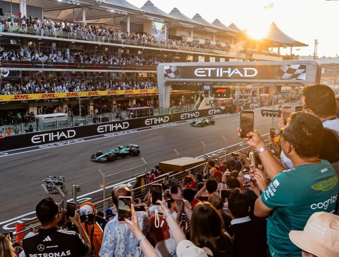Fans in the Main Grandstand as the cars pass the pit wall